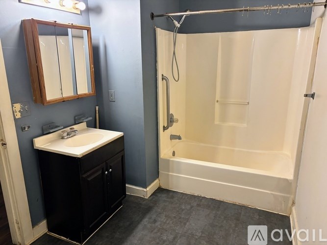 A bathroom with a sink, mirror, and shower.