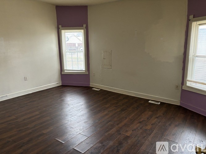 A room with purple walls and wooden flooring.