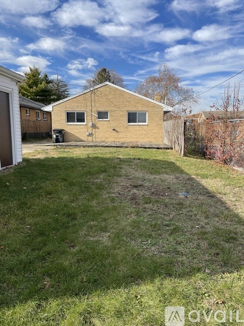 A backyard with a lawn and a house in the background.