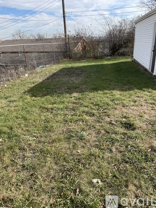 A backyard with a fence and a shed.