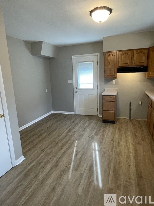A room with wooden flooring and a white door.
