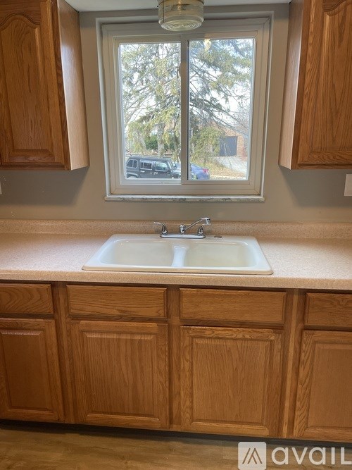 A kitchen with wooden cabinets and a window.