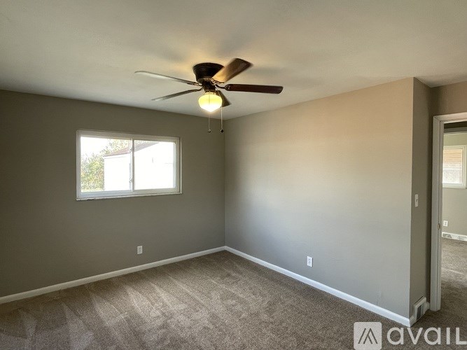 A room with a ceiling fan and a window.