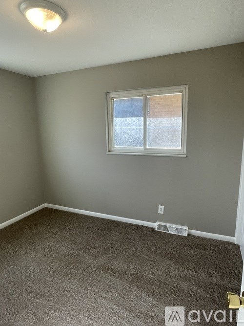 A room with a carpeted floor and a window.