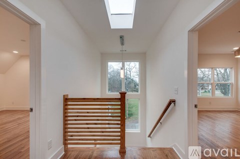 A room with a skylight and a wooden staircase.