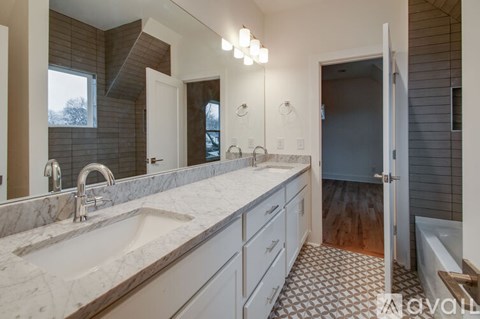 A bathroom with a marble countertop and a walk-in shower.