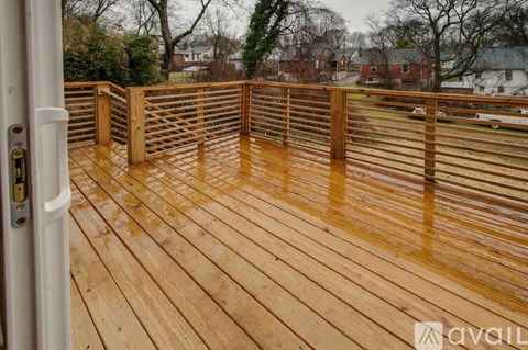 A wooden deck with a white door and a railing.