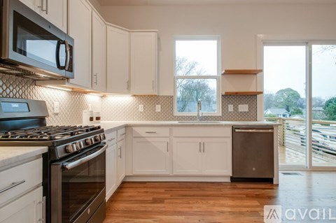 A kitchen with white cabinets and a black stove top oven.
