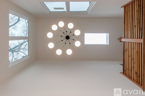 A modern room with a circular light fixture and a skylight.
