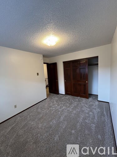 A room with a carpeted floor and a door.