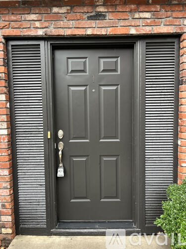 A black door with a keyhole and a key in it.