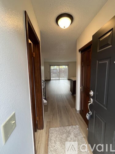 A hallway with a rug on the floor and a door on the right.