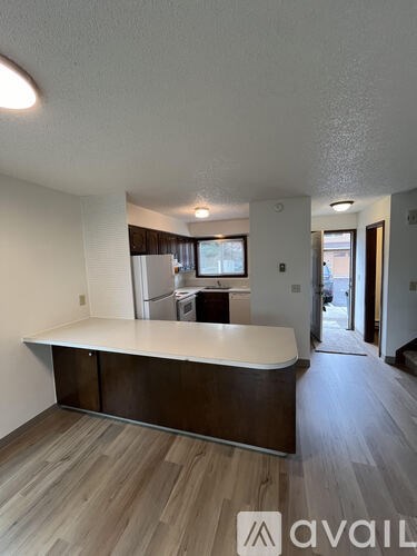 A room with a white counter and wooden flooring.