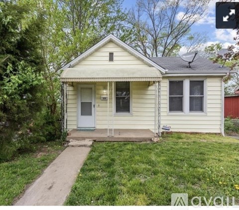 A small house with a white door and a porch.