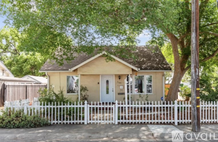 A house with a white picket fence in front of it.