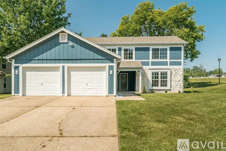 A blue house with a white garage door is for sale.