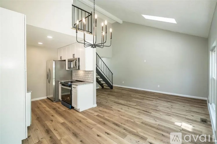A kitchen with wooden floors and a staircase.