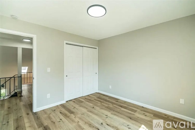 A room with wooden flooring and a white door.