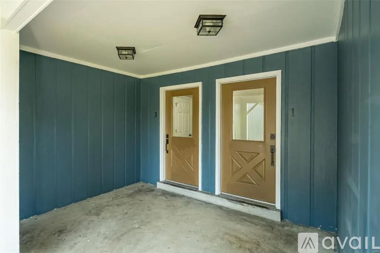 A room with two doors and a wall with a logo on it.