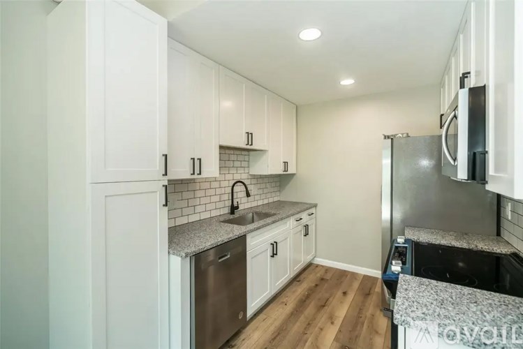 A kitchen with white cabinets and a stainless steel dishwasher.