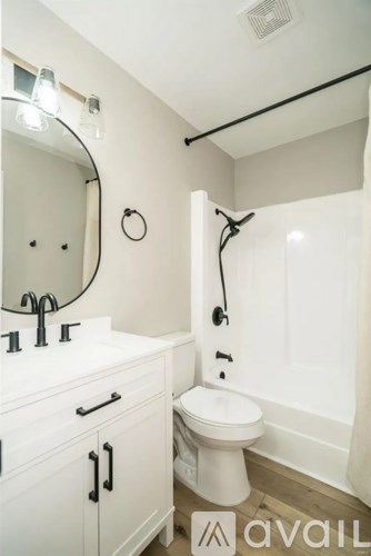 A bathroom with a toilet, sink, and mirror.