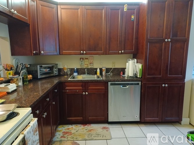A kitchen with wooden cabinets and a white dishwasher.