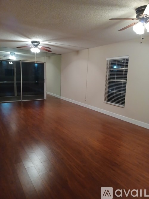 A room with wooden flooring and a ceiling fan.