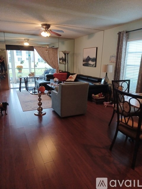 A dog is standing in a living room with a brown couch and a coffee table.