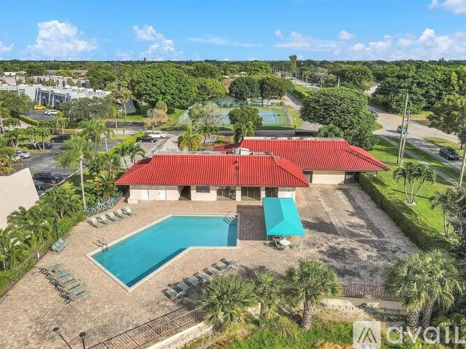 A red-roofed building with a blue pool in front.