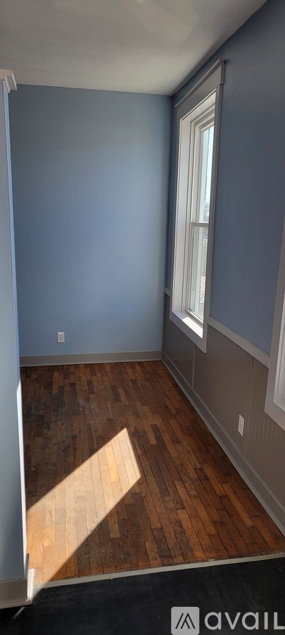 A room with a window and wooden flooring.
