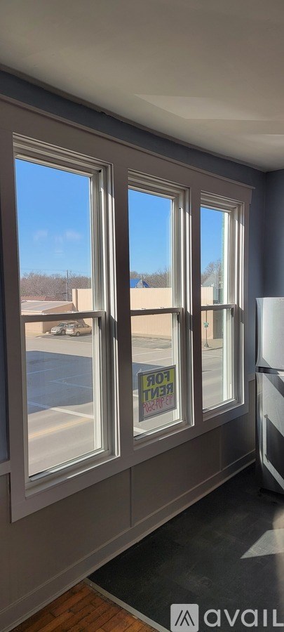 A room with a window overlooking a parking lot.