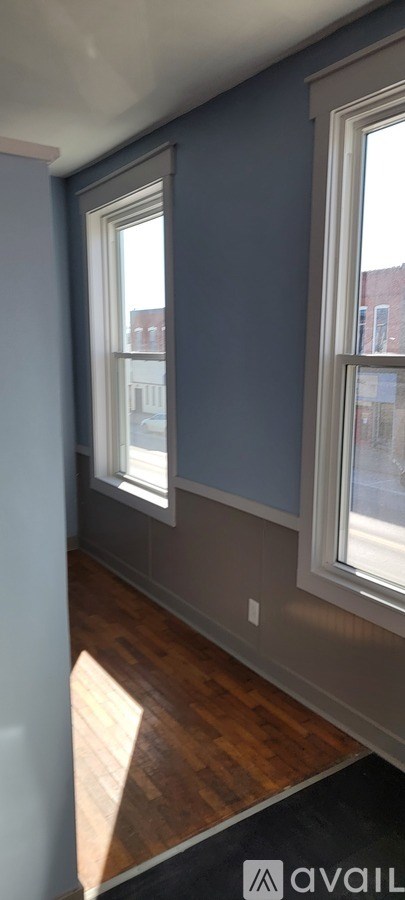 A room with a window and a wooden floor.