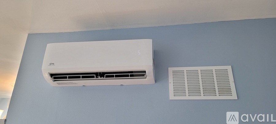 A wall-mounted air conditioner unit is installed on a blue wall.