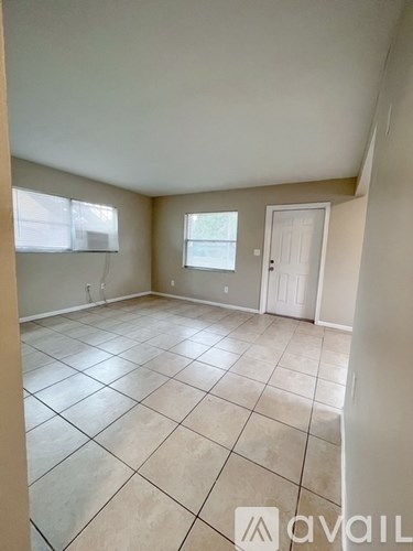 A room with tiled flooring and a door is available for rent.