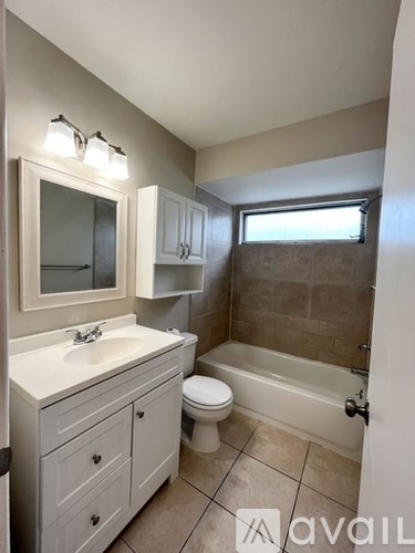 A bathroom with a toilet, sink, and bathtub.