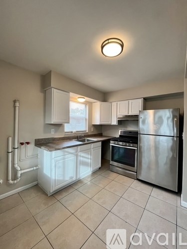 A kitchen with a refrigerator, sink, and stove.