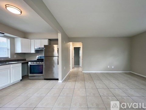 A kitchen with white cabinets and a stainless steel refrigerator.