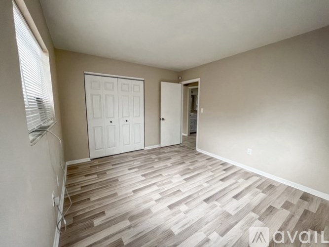 A room with wooden flooring and two doors.