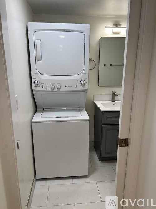 A white washing machine and dryer in a small bathroom.