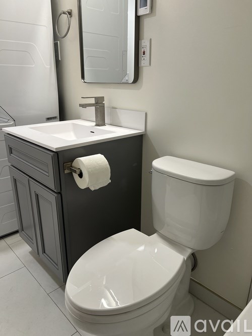 A white toilet sits next to a sink in a bathroom.