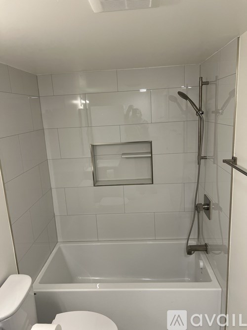 A white bathroom with a toilet, tub, and shower.