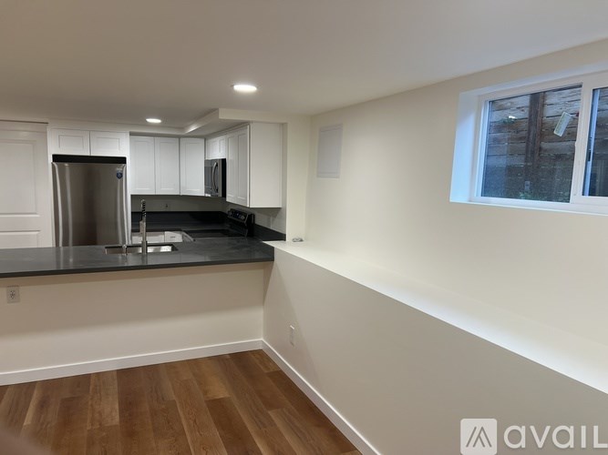 A kitchen with white cabinets and a black countertop.