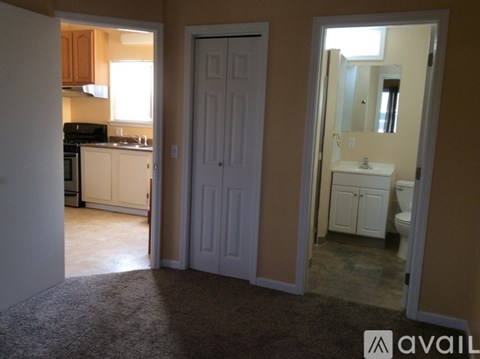 A bathroom with a sink, mirror, and toilet is visible through a doorway.