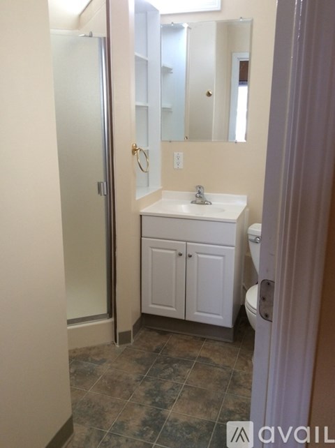 A bathroom with a sink, toilet and a mirror.