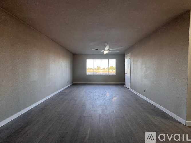 Empty room with wooden flooring and a window.