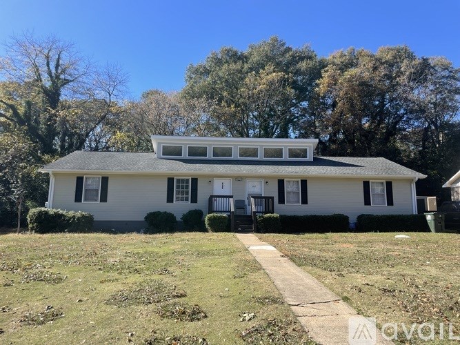 A white house with a grey roof and a small porch.