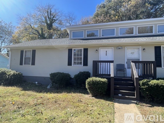A two-story house with a white front door and black shutters.