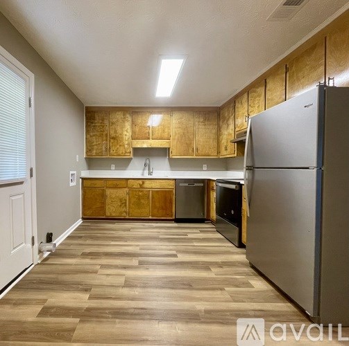A kitchen with wooden cabinets and a refrigerator.