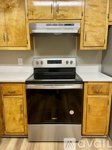 A kitchen with wooden cabinets and a stainless steel oven.