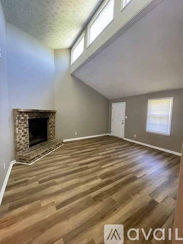 A room with a fireplace and wooden flooring.